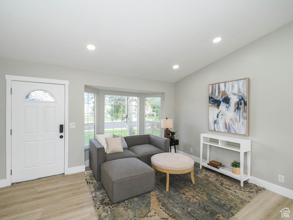 Living room with light wood-type flooring and vaulted ceiling