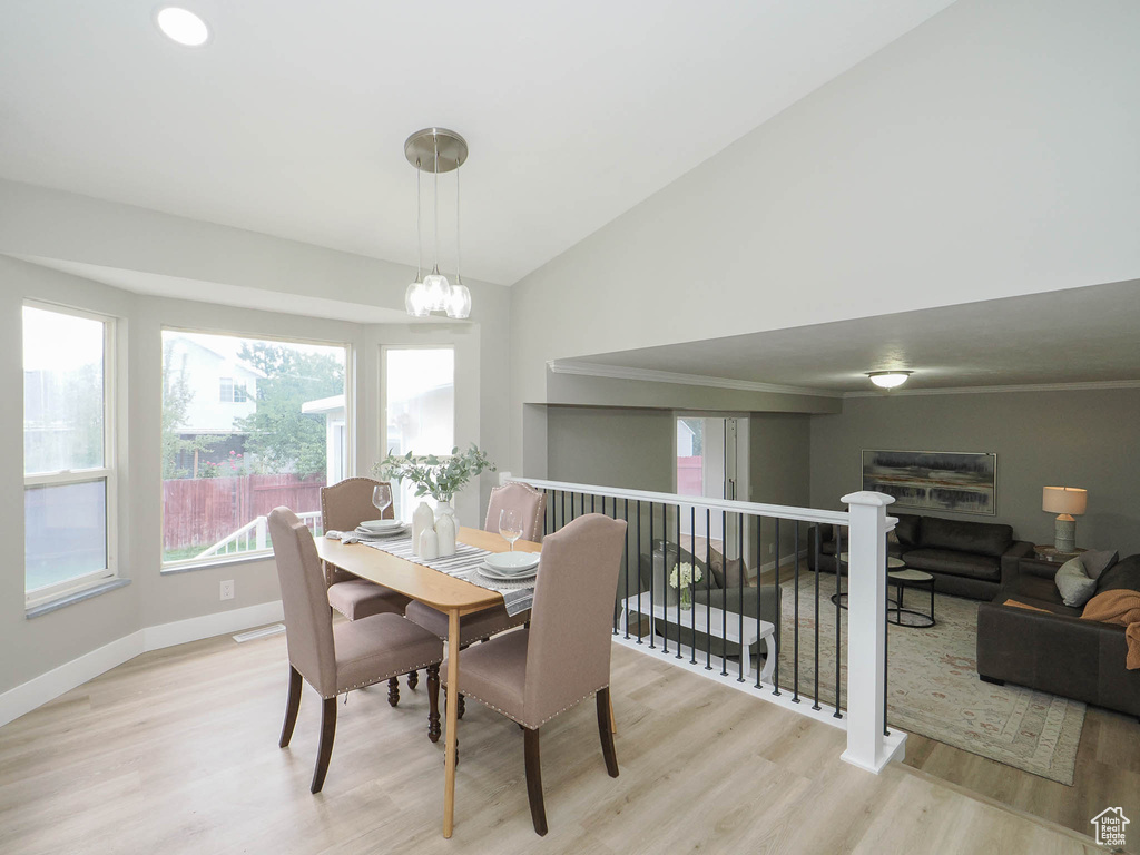 Dining room with lofted ceiling, an inviting chandelier, and light hardwood / wood-style floors