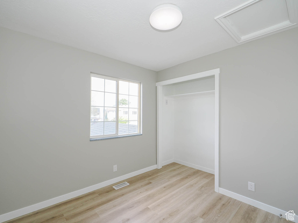 Unfurnished bedroom with a closet and light hardwood / wood-style flooring