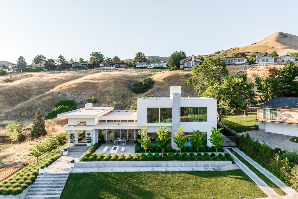 Rear view of house featuring a yard, a patio area, and a mountain view