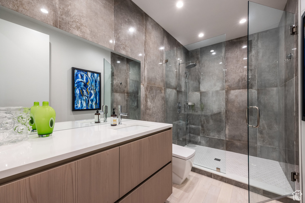 Bathroom with an enclosed shower, hardwood / wood-style floors, toilet, and vanity