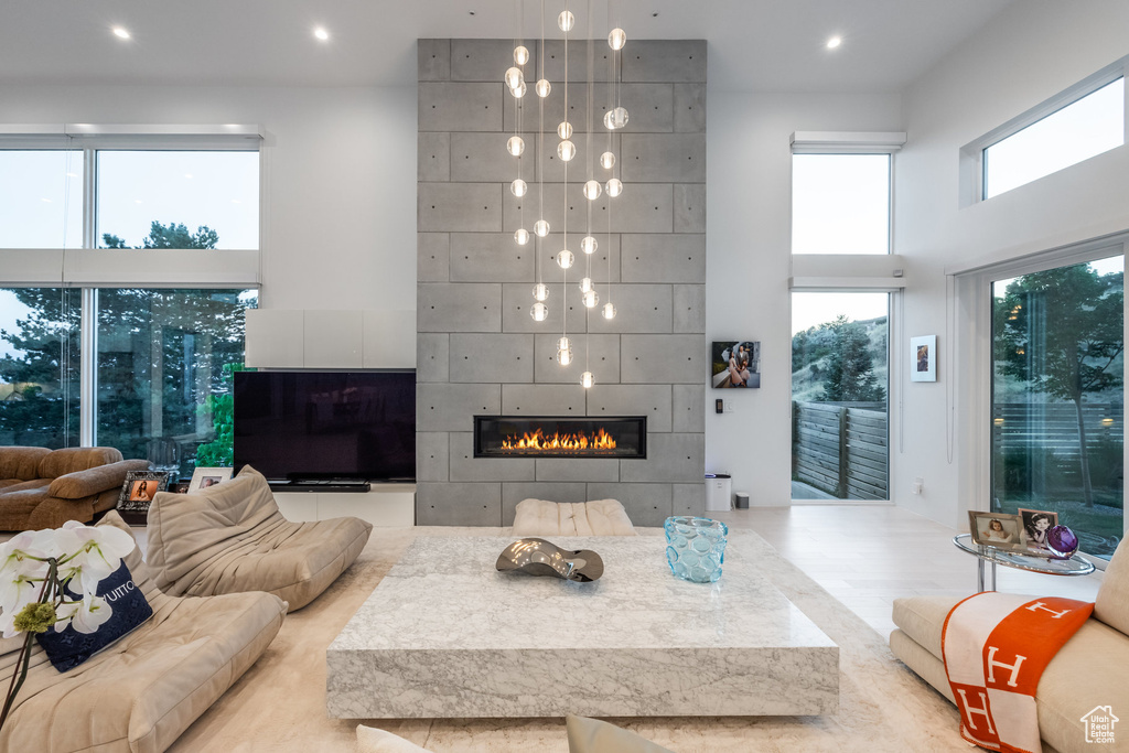 Living room featuring a tile fireplace and a towering ceiling