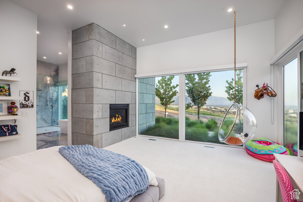 Bedroom with a tiled fireplace and ensuite bathroom