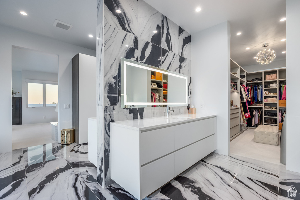 Bathroom with a chandelier, tasteful backsplash, and vanity