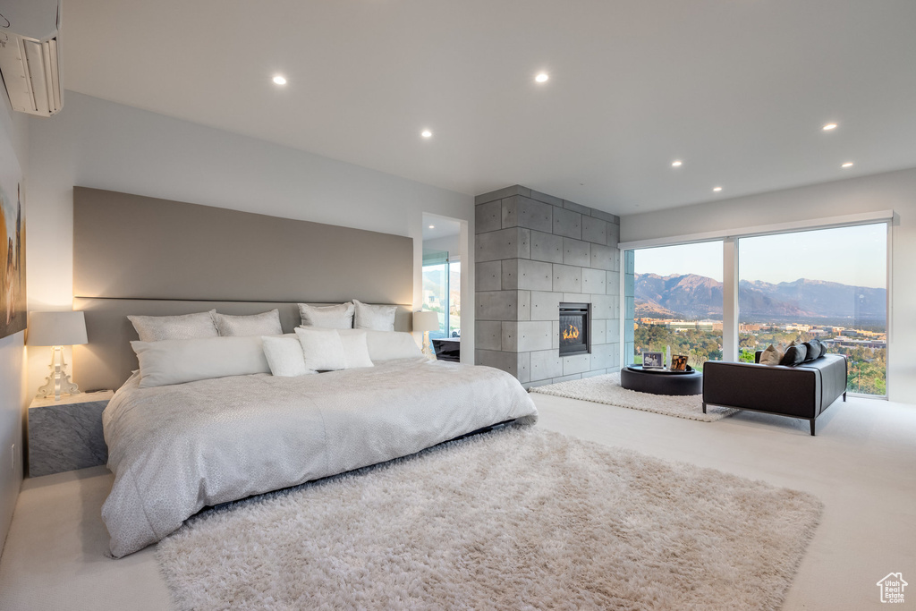 Bedroom with a tiled fireplace, a mountain view, and concrete flooring