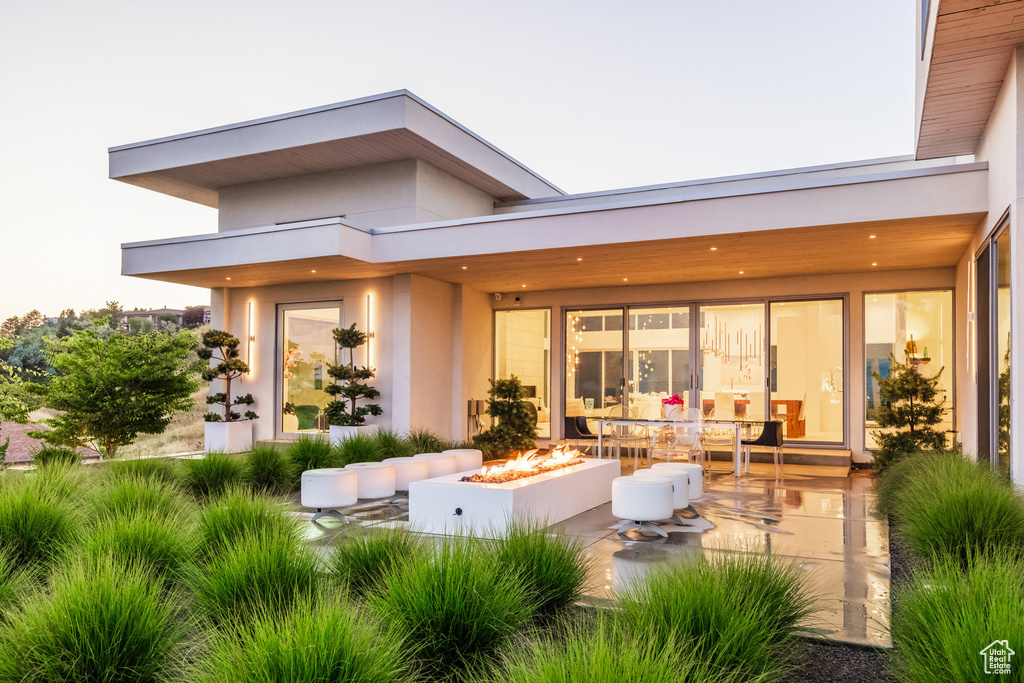 Rear view of property with a fire pit and a patio