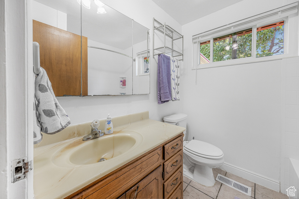 Full bathroom featuring tile patterned flooring, vanity, toilet, and shower / washtub combination