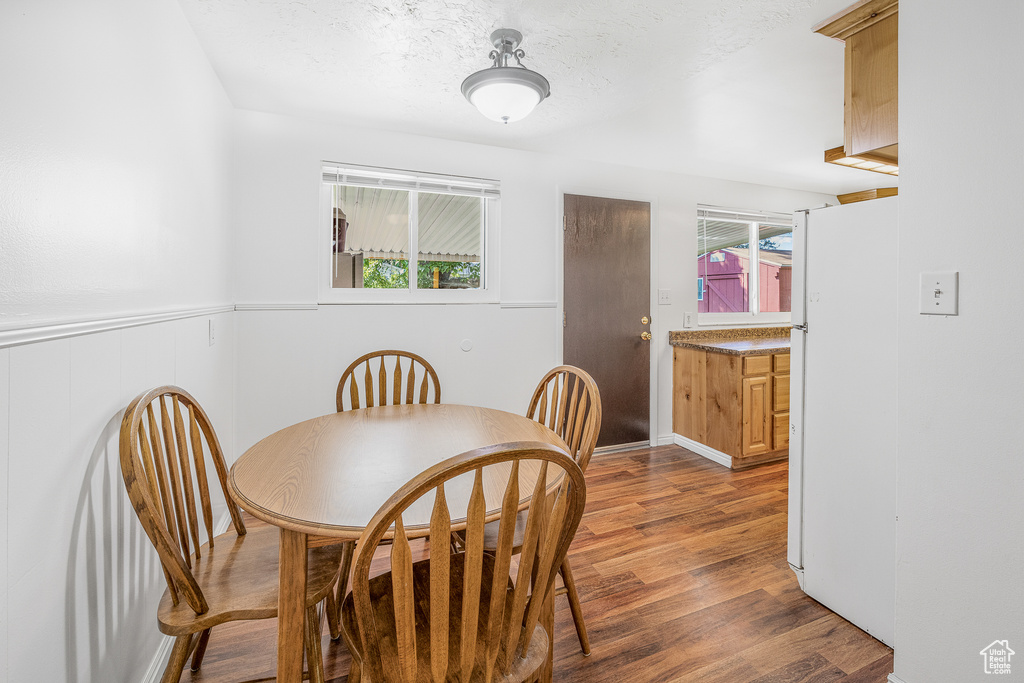 Dining room with a wealth of natural light and dark wood-type flooring