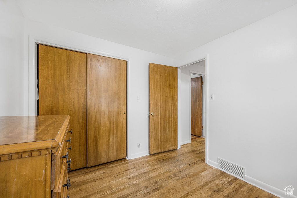 Unfurnished bedroom with a closet and light wood-type flooring