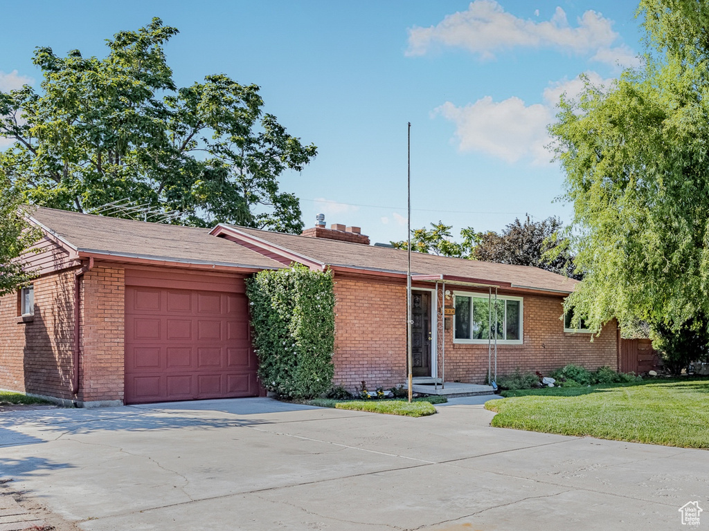 Ranch-style home with a garage and a front yard