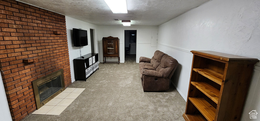 Carpeted living room with a brick fireplace and a textured ceiling