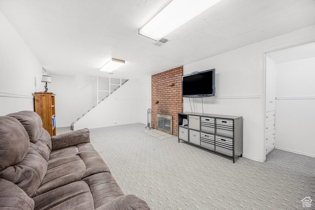 Carpeted living room with a brick fireplace