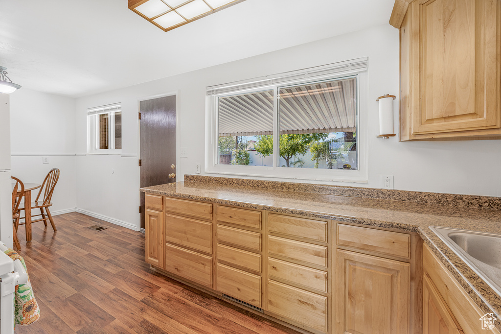 Kitchen with hardwood / wood-style floors and light brown cabinets