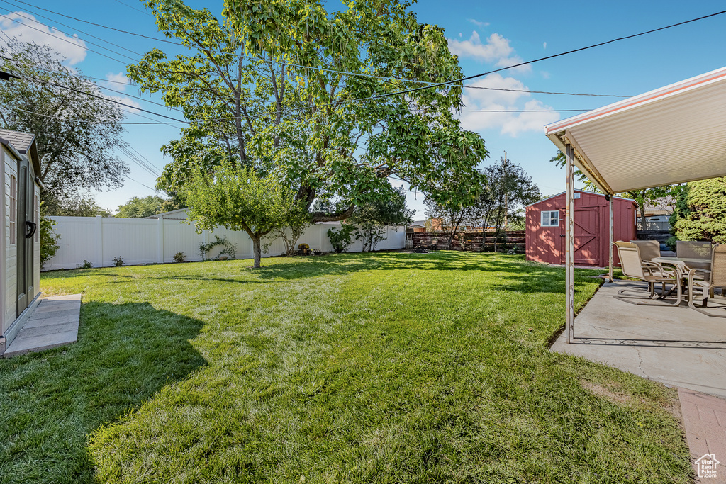 View of yard featuring a storage shed and a patio area