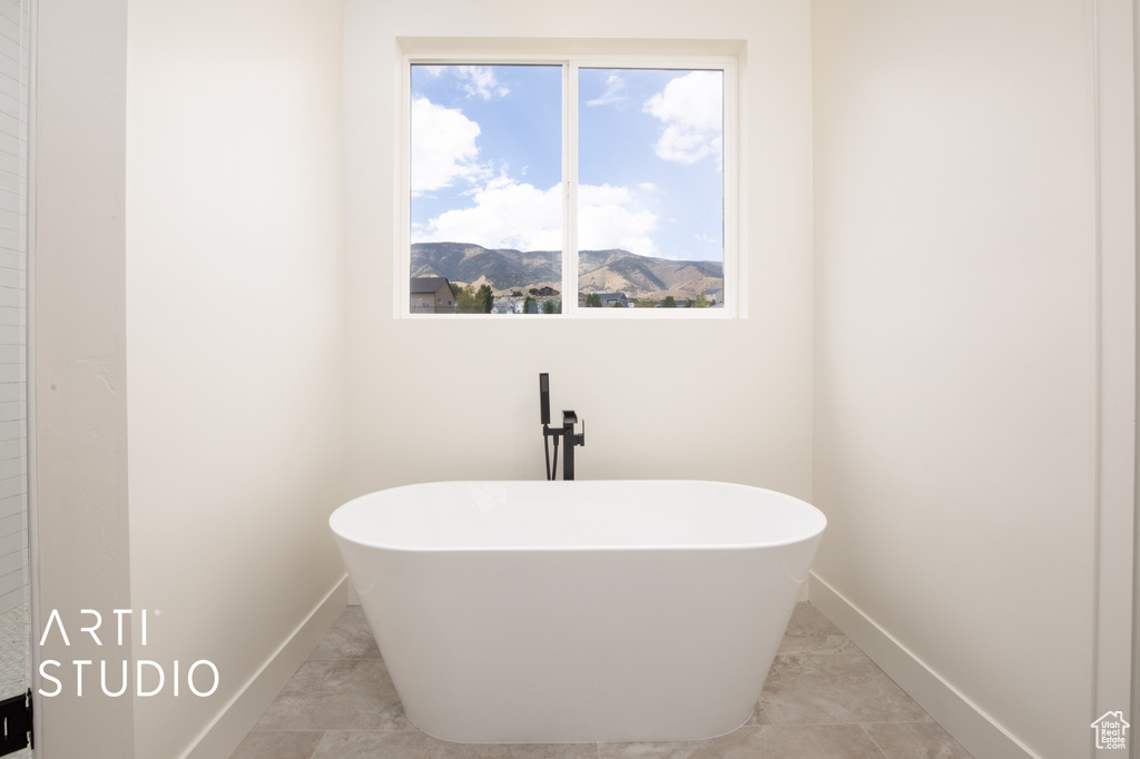 Bathroom featuring a mountain view, plenty of natural light, and a bathing tub