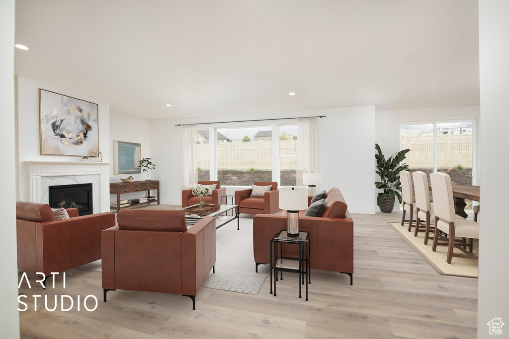 Living room with a fireplace and light hardwood / wood-style flooring