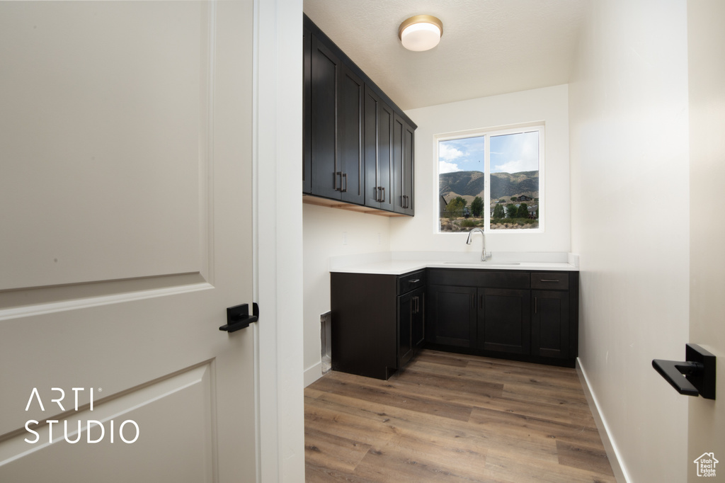 Laundry room featuring sink and light hardwood / wood-style floors