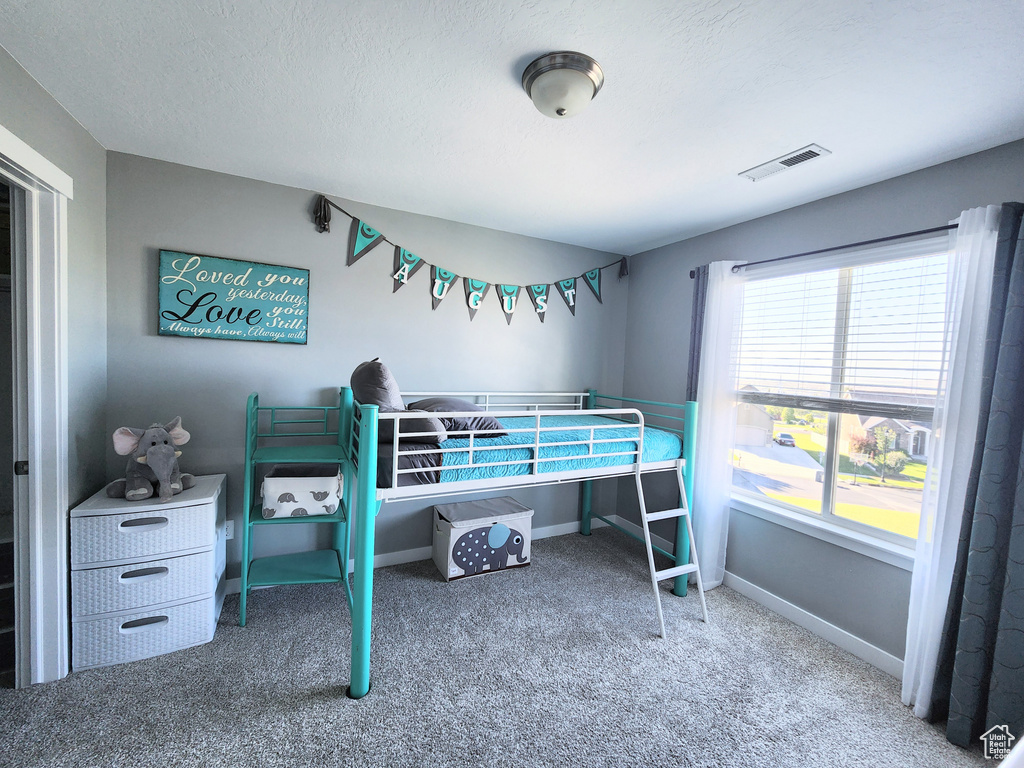 Carpeted bedroom featuring a textured ceiling