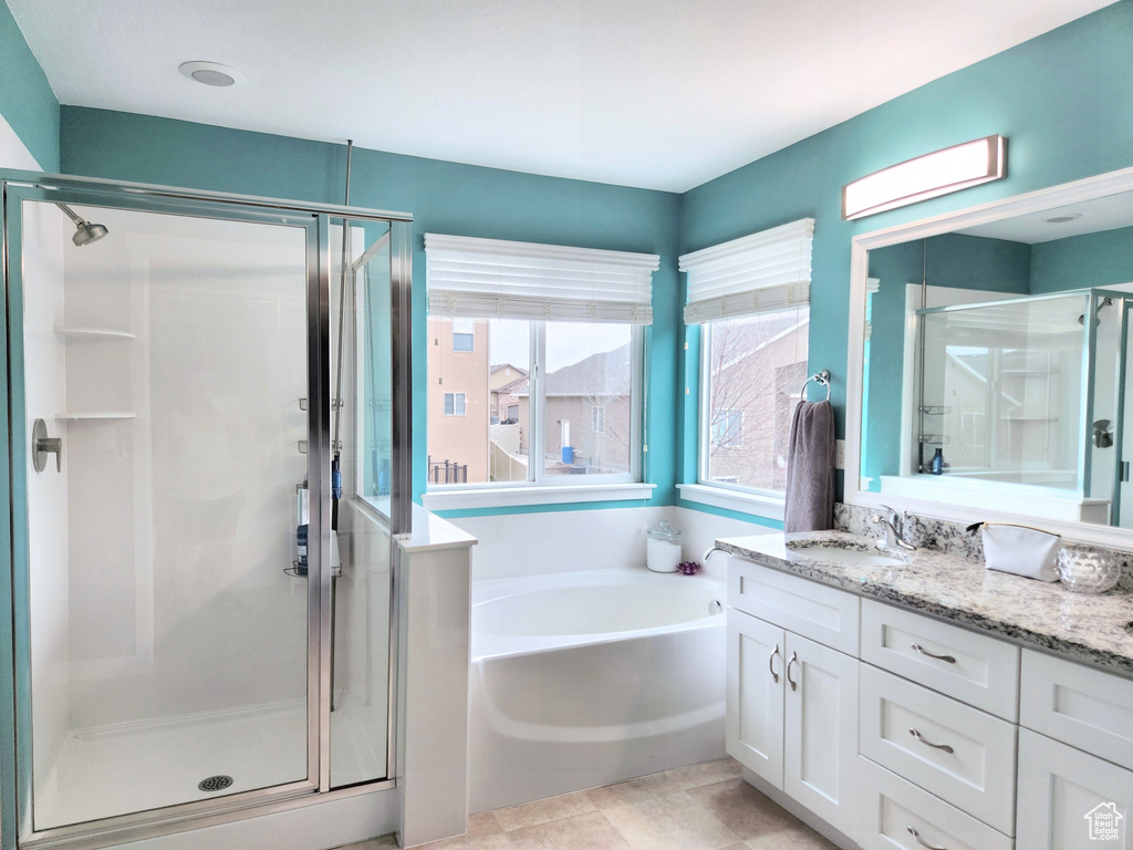 Bathroom featuring tile patterned flooring, vanity, and independent shower and bath