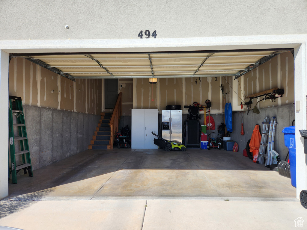 Garage with stainless steel refrigerator with ice dispenser