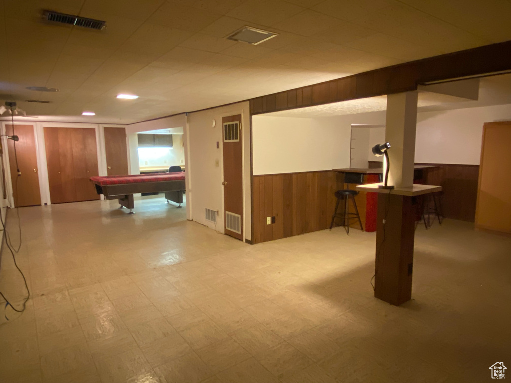 Basement featuring billiards and wood walls