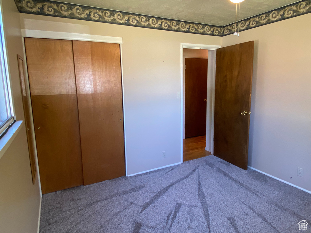 Unfurnished bedroom featuring a closet and carpet floors