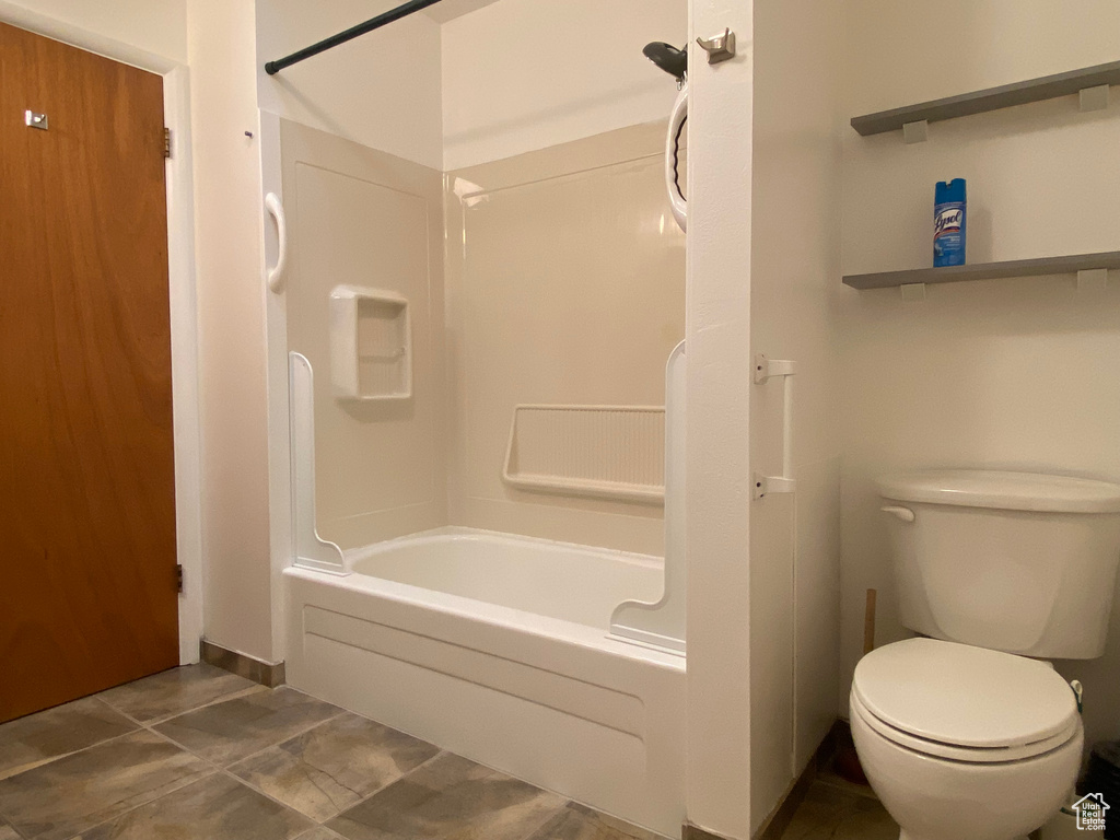 Bathroom with toilet, shower / tub combination, and tile patterned floors