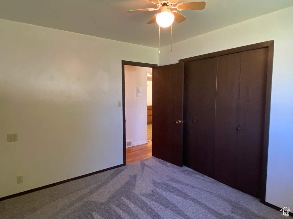 Unfurnished bedroom with a closet, ceiling fan, and light carpet