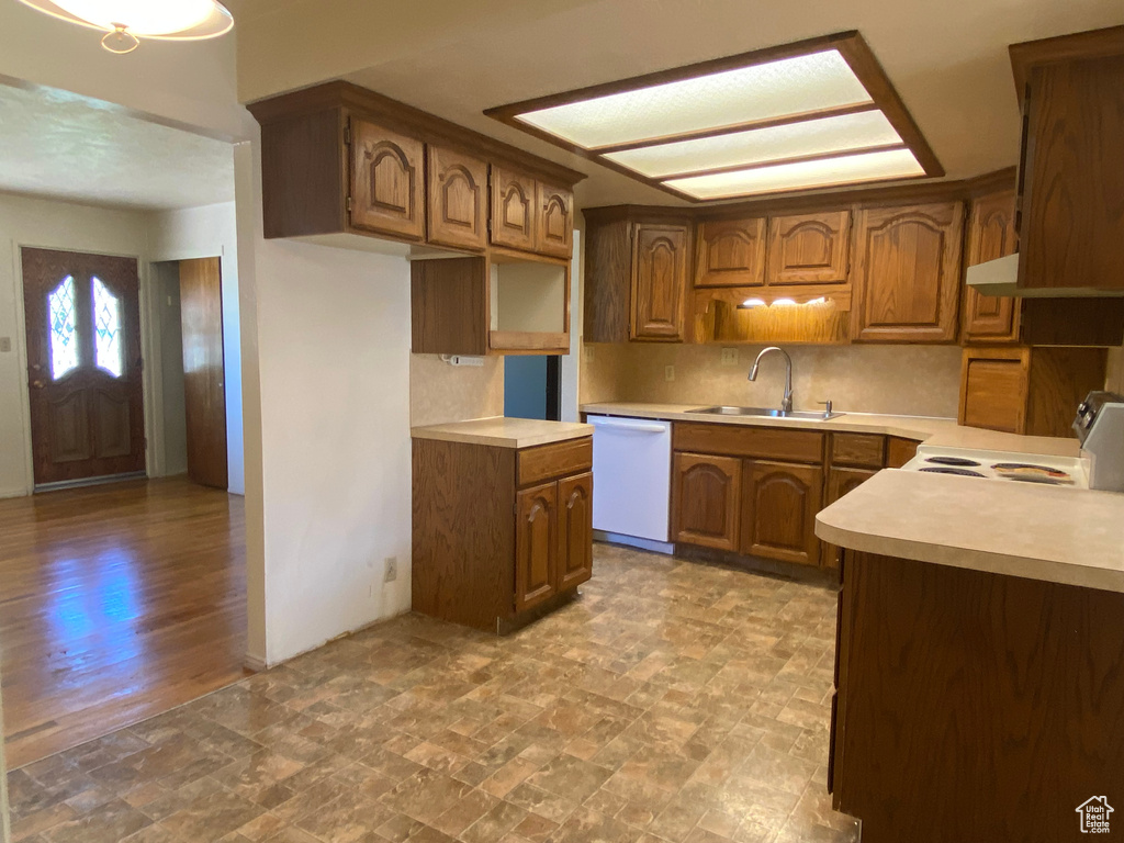 Kitchen with white appliances, light hardwood / wood-style flooring, sink, and decorative backsplash