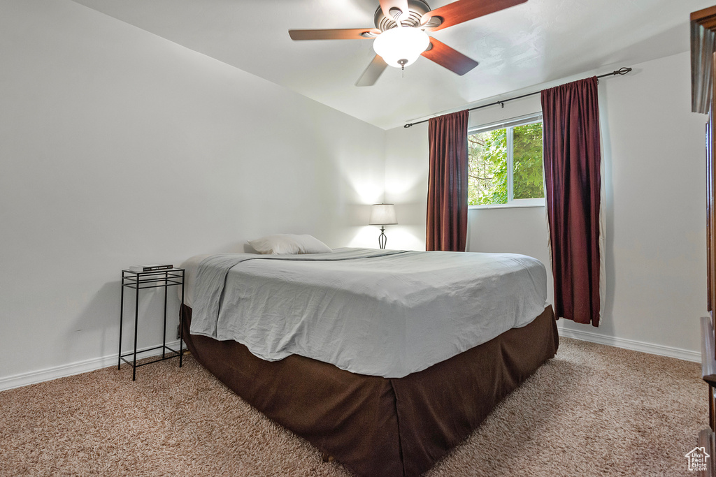 Bedroom with ceiling fan and light carpet