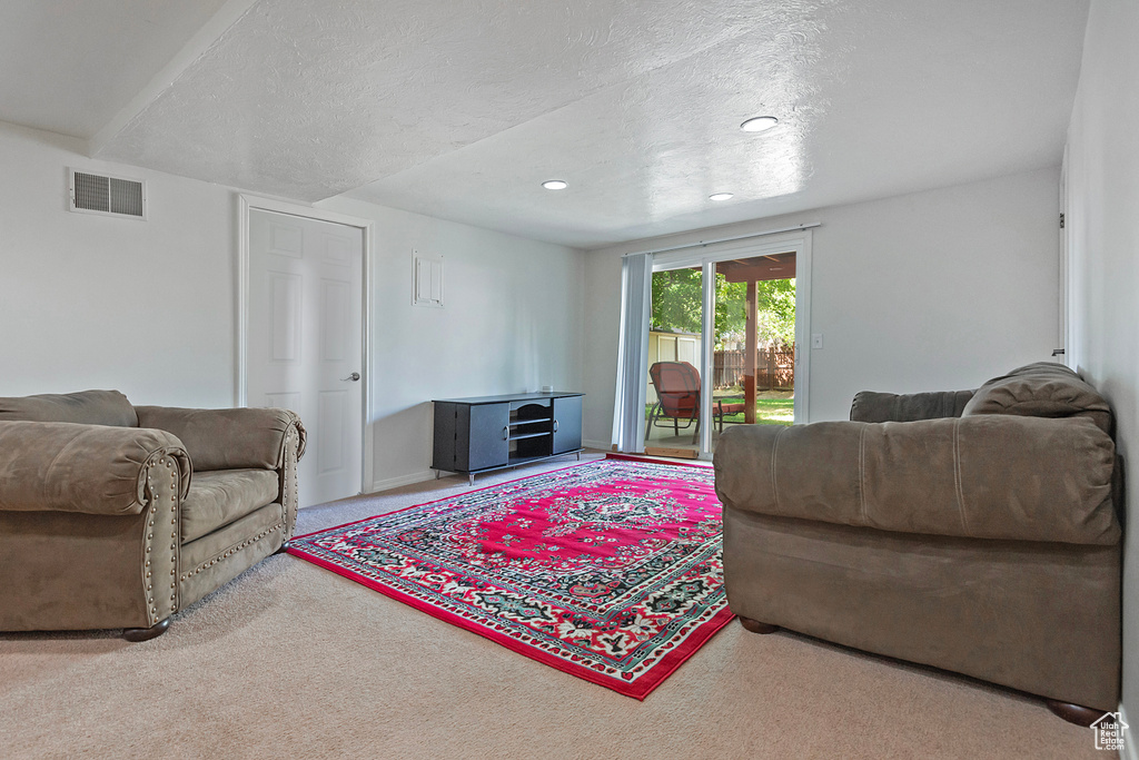 Living room featuring a textured ceiling and light colored carpet