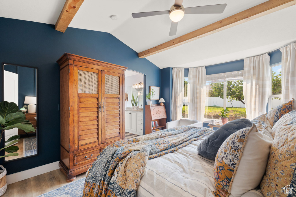 Bedroom featuring ceiling fan, hardwood / wood-style floors, and lofted ceiling with beams