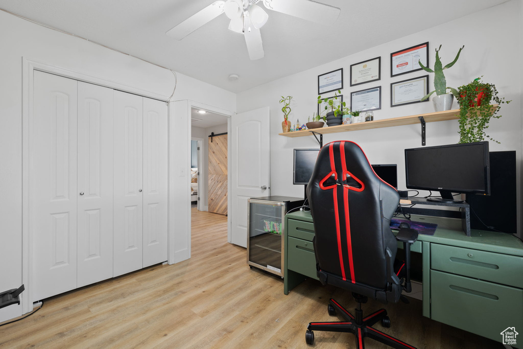 Office space featuring ceiling fan and light hardwood / wood-style floors