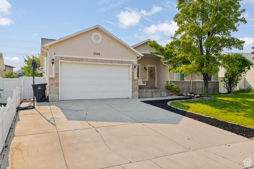 Single story home featuring a garage and a front lawn