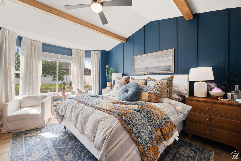 Bedroom featuring ceiling fan, lofted ceiling with beams, and wood-type flooring