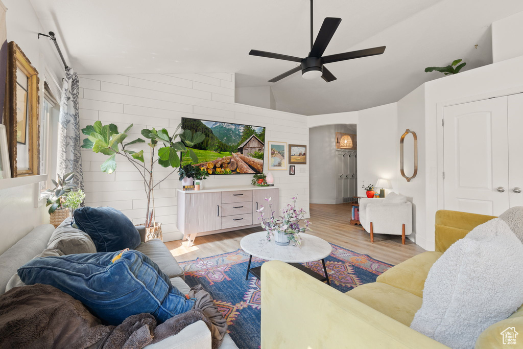 Living room featuring vaulted ceiling, light wood-type flooring, and ceiling fan