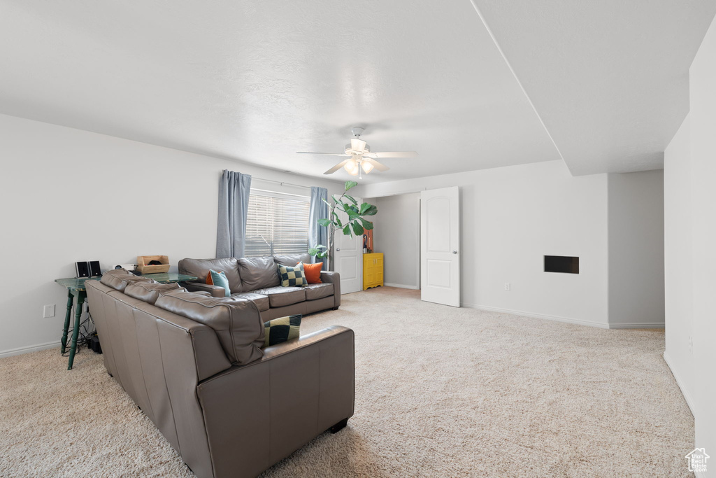 Carpeted living room with ceiling fan