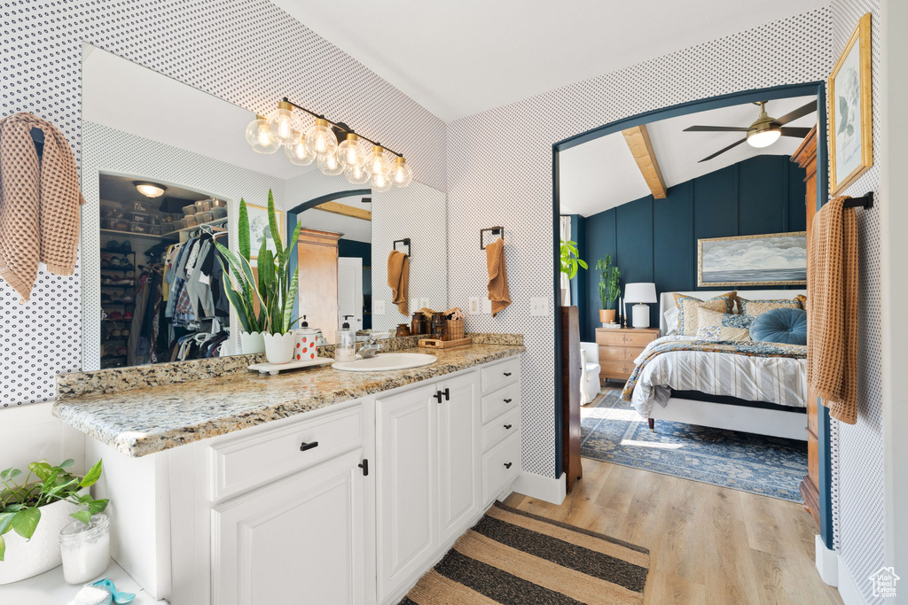 Bathroom with vanity, hardwood / wood-style floors, ceiling fan, and vaulted ceiling with beams