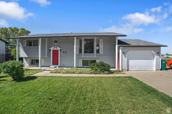 Bi-level home with a front yard and a garage