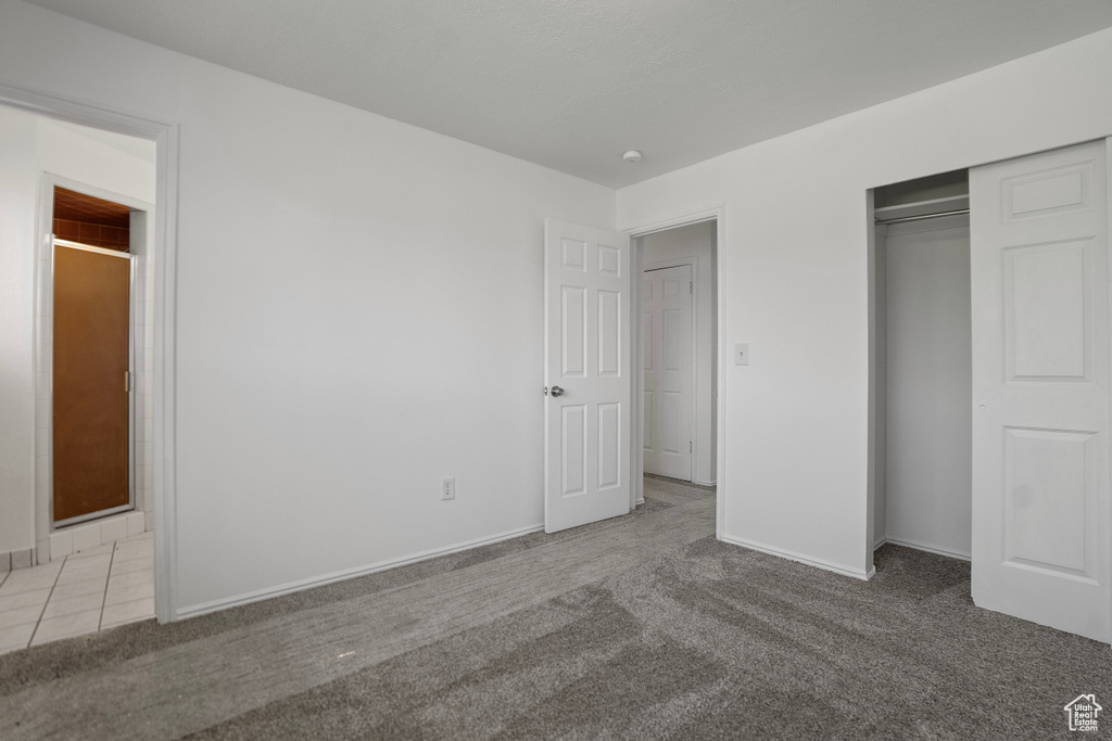 Unfurnished bedroom with light colored carpet and a closet