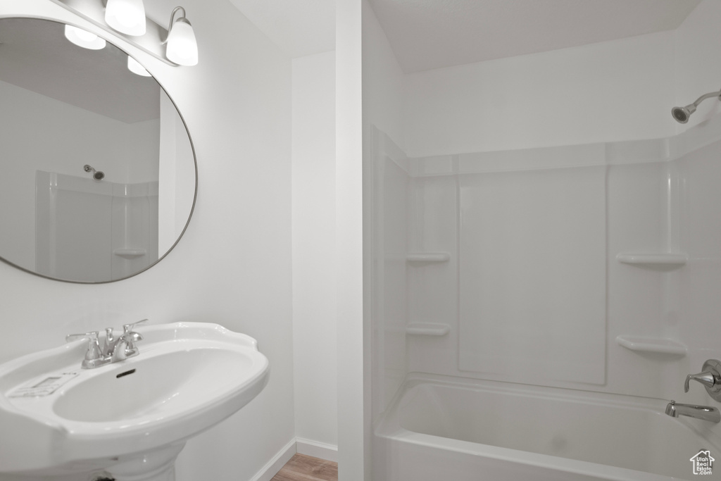 Bathroom with wood-type flooring,  shower combination, and sink