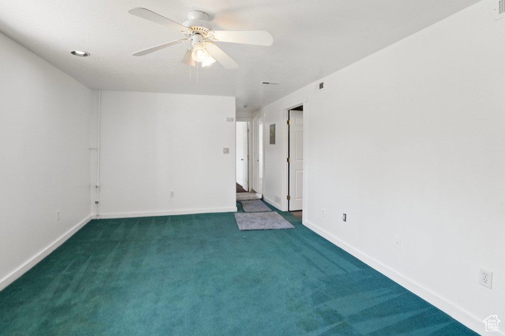 Carpeted spare room featuring ceiling fan