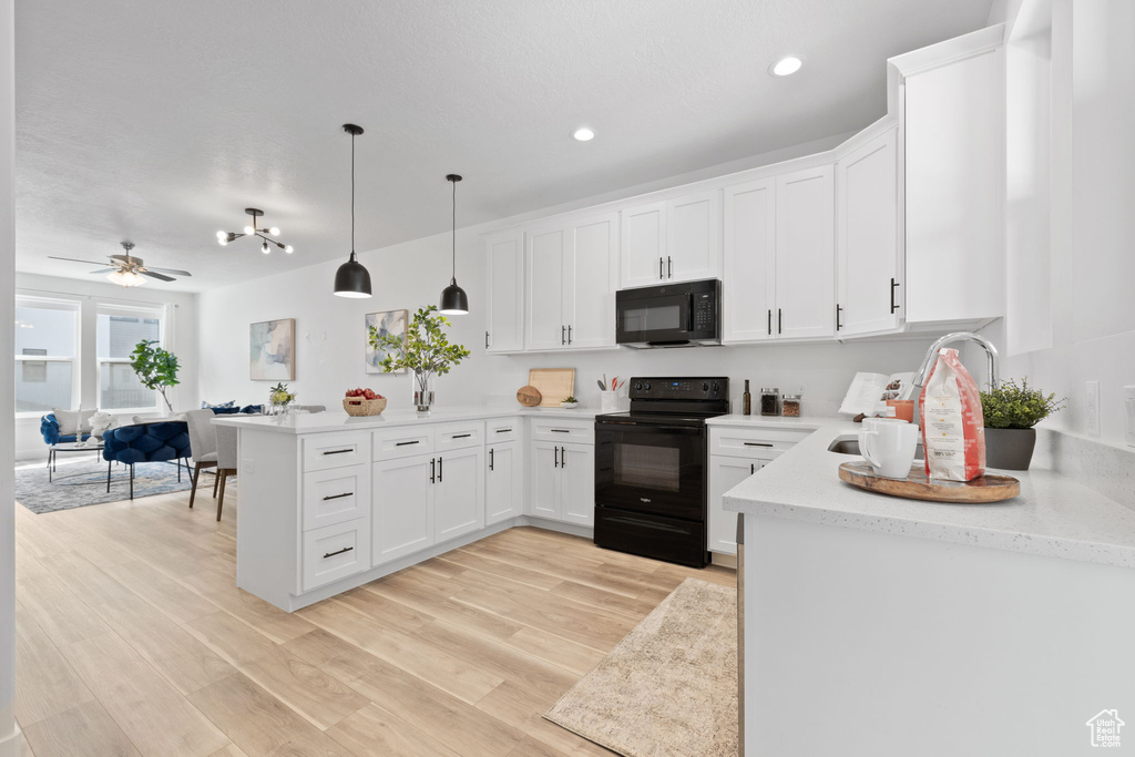 Kitchen featuring black appliances, pendant lighting, white cabinetry, and ceiling fan