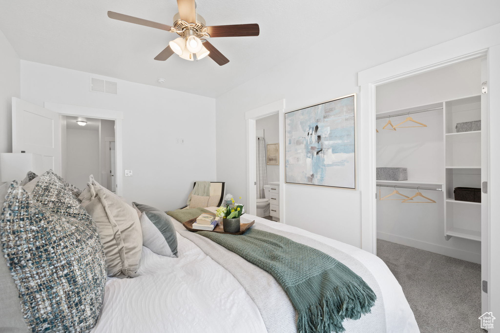 Carpeted bedroom featuring ceiling fan, a closet, and ensuite bathroom