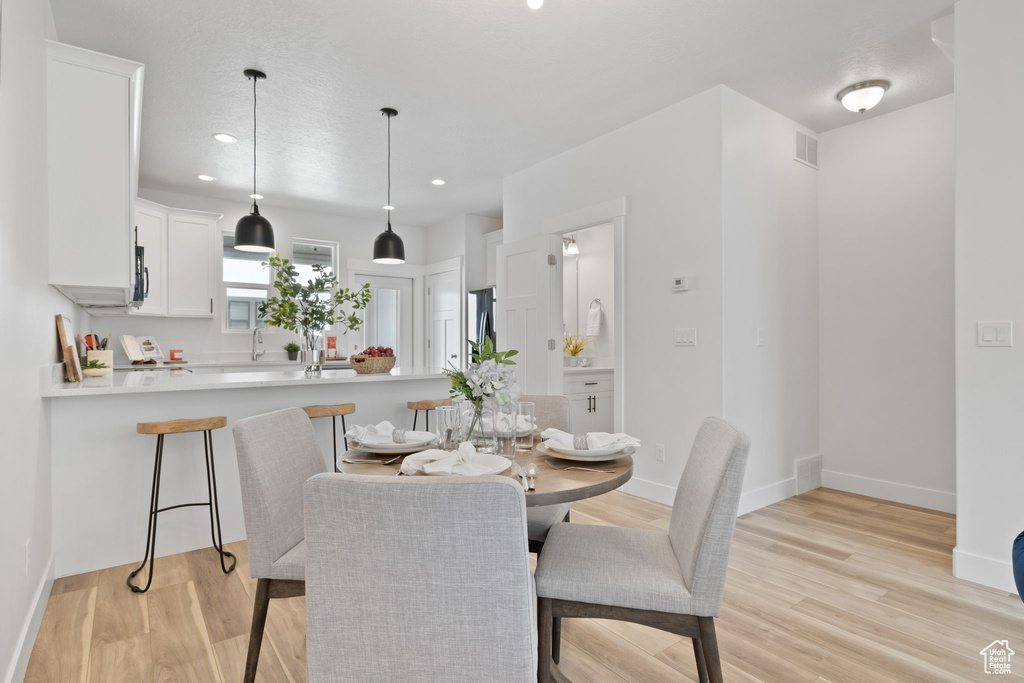 Dining space with a textured ceiling and light hardwood / wood-style floors