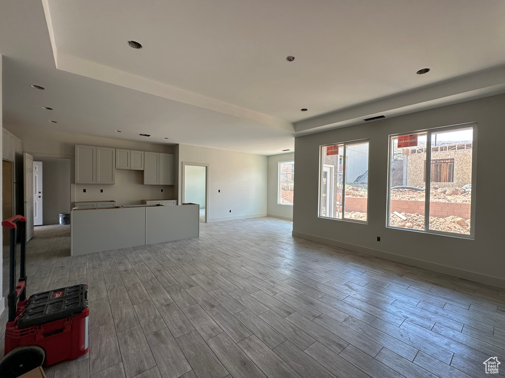 Unfurnished living room with light hardwood / wood-style flooring and a healthy amount of sunlight