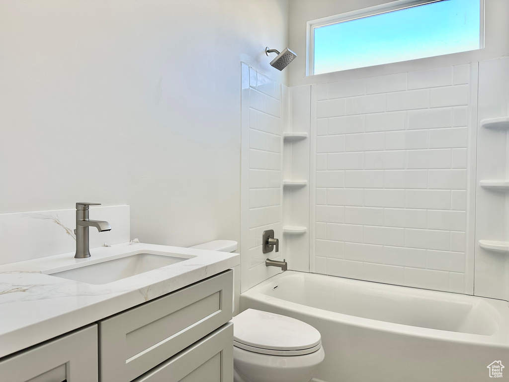 Full bathroom featuring toilet, vanity, and tiled shower / bath