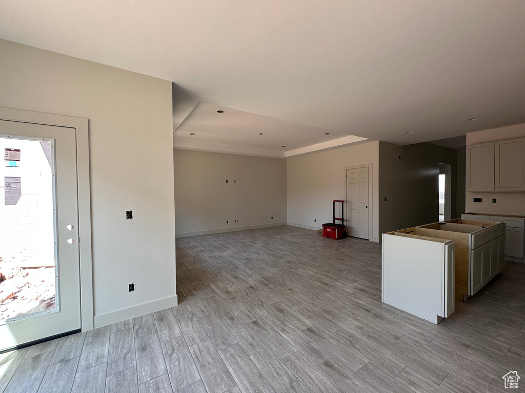 Kitchen featuring light wood-type flooring and a raised ceiling