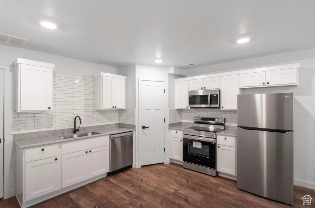 Kitchen featuring white cabinets, stainless steel appliances, dark hardwood / wood-style flooring, and sink