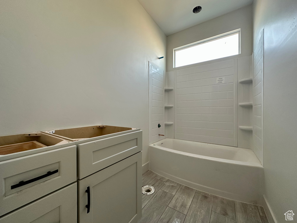 Bathroom with vanity, bathtub / shower combination, and hardwood / wood-style floors